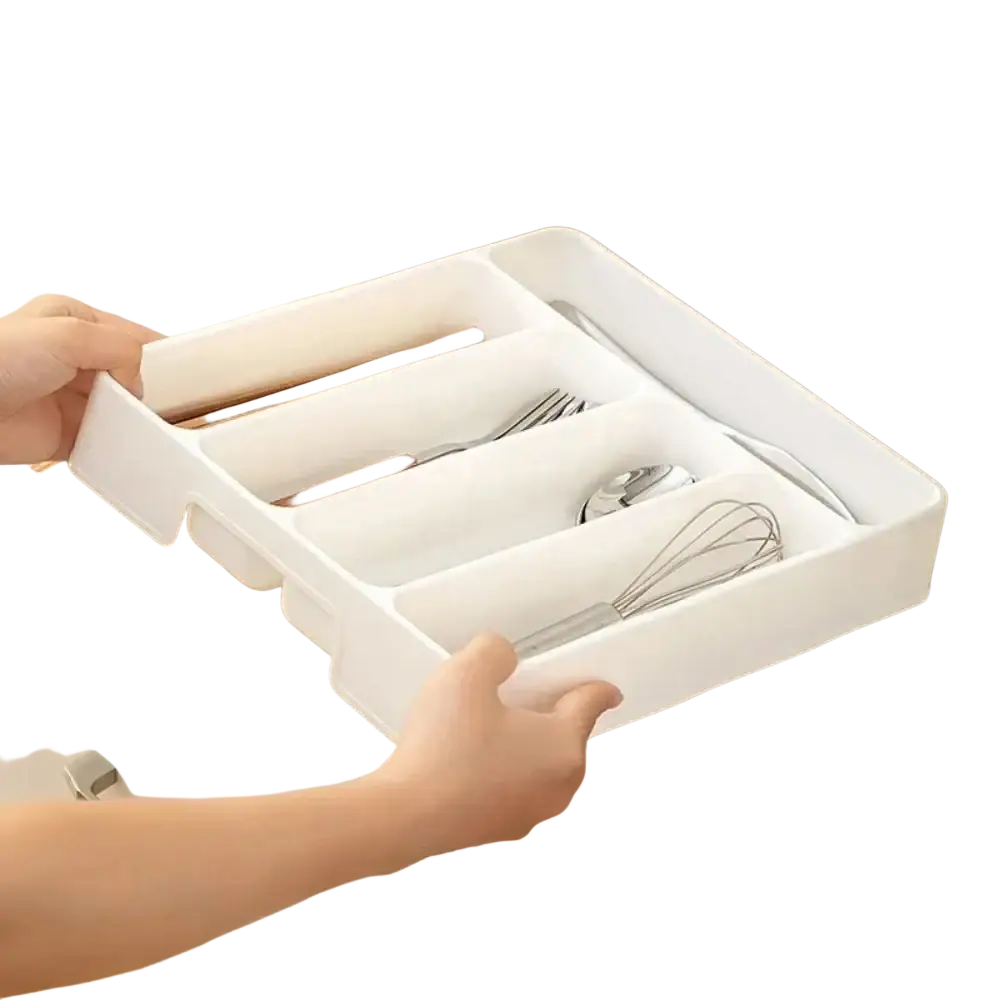 White plastic cutlery drawer organizer with four compartments neatly holding chopsticks forks spoons and a whisk