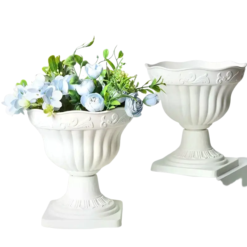 White plastic roman column urn planter with fluted sides and scrollwork filled with light blue artificial flowers
