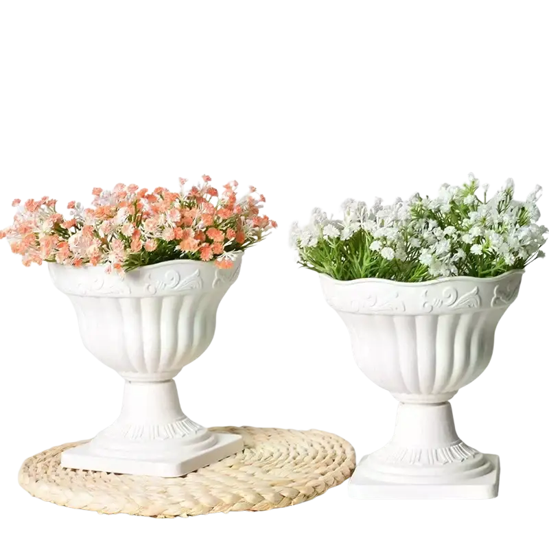 Two white plastic roman column urn planters with ornate fluted design and scalloped rims for flowers