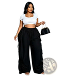 Black faux leather clutch with chain strap and gold tone hardware complementing pleated high waist wide leg cargo pants
