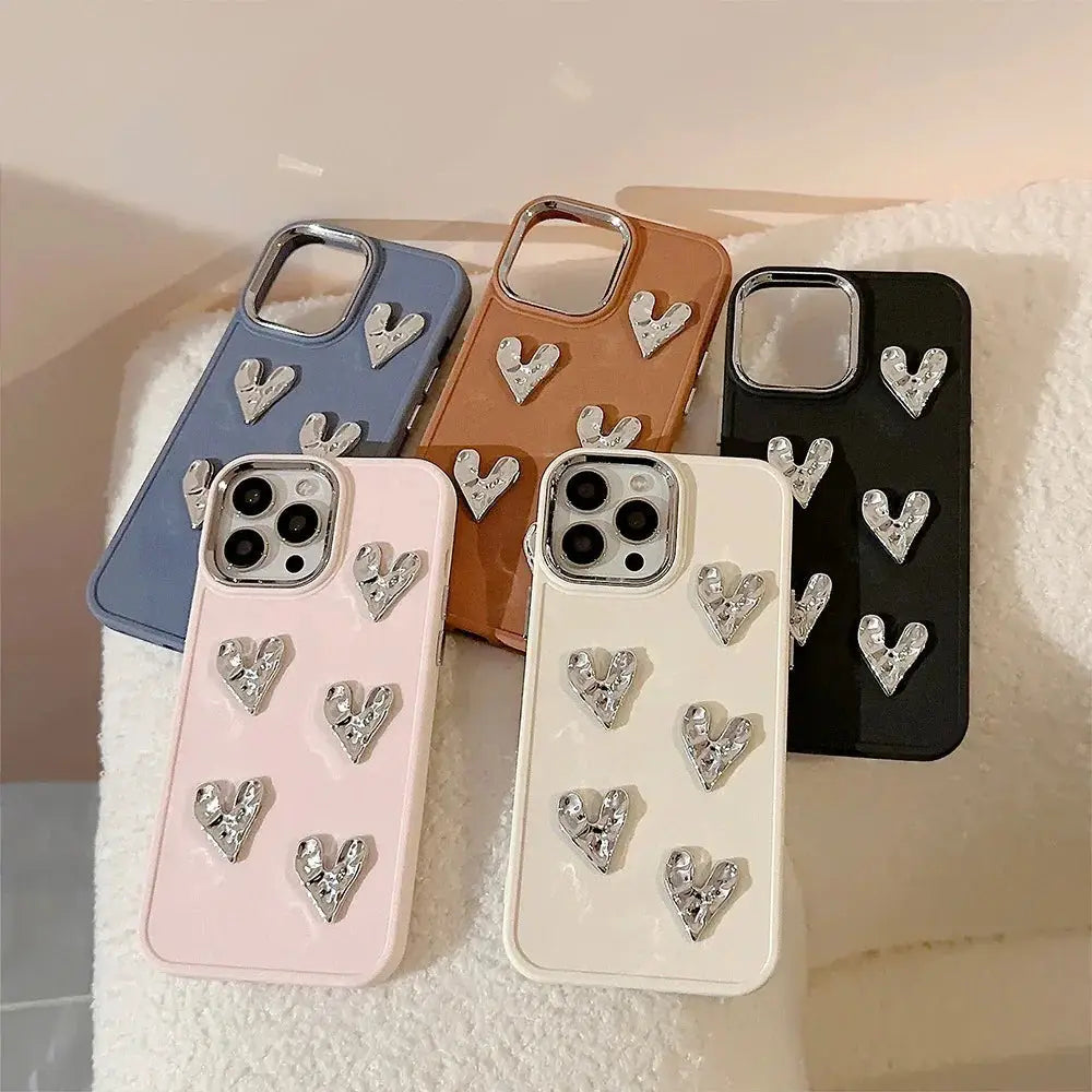 Pleated metallic heart charm phone cases shown from the back in pastel pink creamy white soft blue and warm brown with silver sparkles