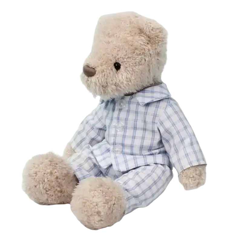 A plush bear stuffed animal in beige wearing a light blue and white checkered pajama set for sleeping comfort