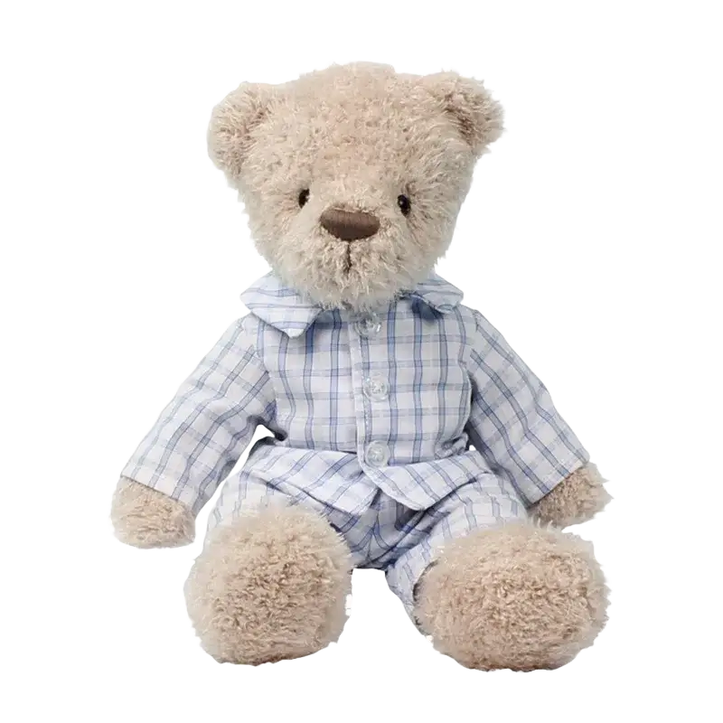 A soft cream-colored plush bear stuffed animal wearing light blue and white plaid pajamas with buttons