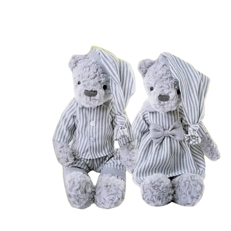 Two plush bear stuffed animals dressed in matching gray and white striped pajamas one with a bow tie