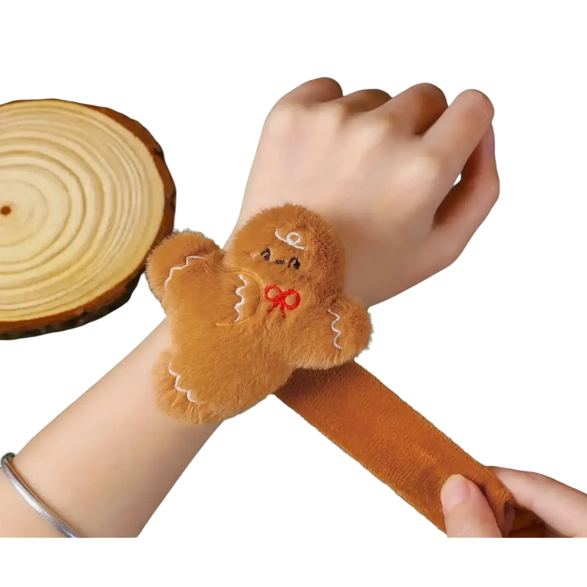 A soft brown plush gingerbread man christmas slap bracelet with white embroidered icing and a red bow for kids