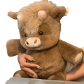 A plush brown highland cow stuffed animal with soft fur pinkish snout and ears dark eyes from plush cow and pig toys
