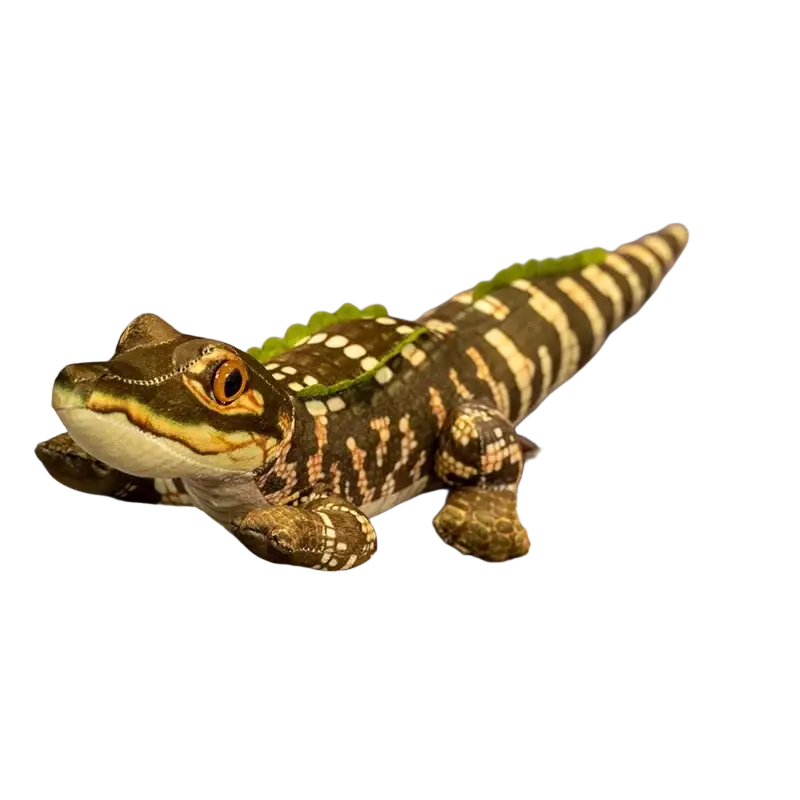 A plush crocodile stuffed animal toy with a green and brown patterned body and yellow stitched eyes