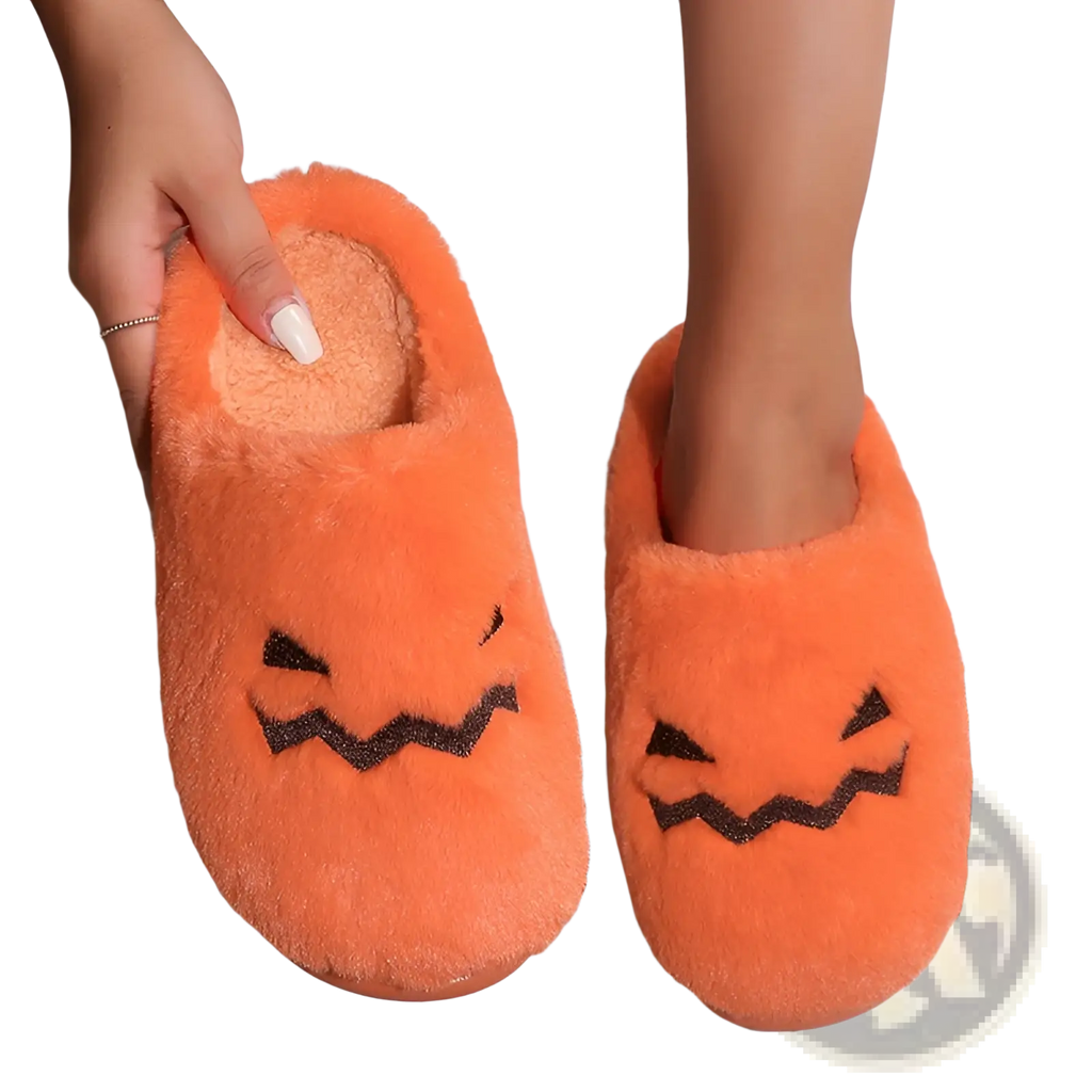 Plush pumpkin Halloween indoor slippers in orange with black embroidered facial features for cozy indoor use