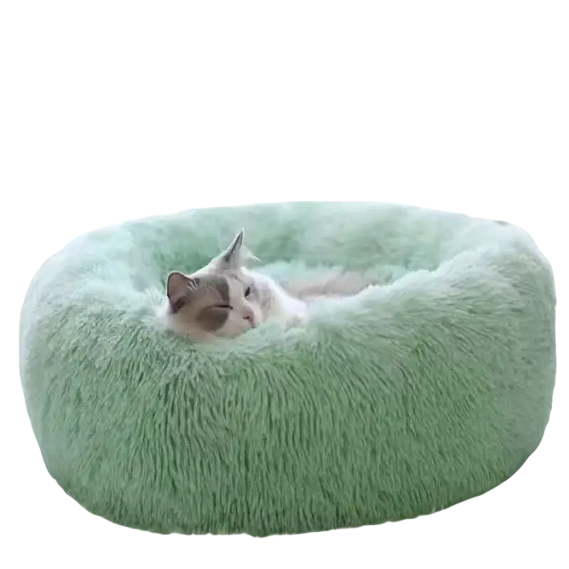 A soft mint green plush round cat bed with fluffy texture for warm cozy pet nesting in gray tones