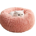 Pink fluffy circular pet bed with soft plush material features a white cat nestled inside for warmth and comfort