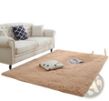 A plush peach-colored shaggy area rug with soft fluffy texture and slightly raised edges in machine washable faux fur