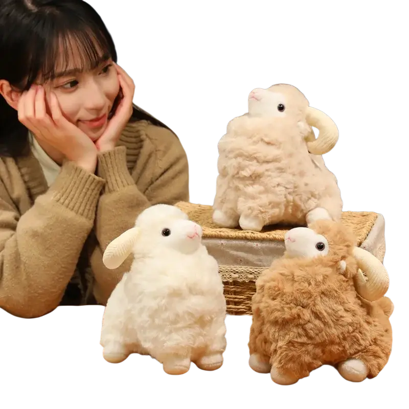 Soft fluffy white and beige plush sheep stuffed animal toy with curved horns on a wooden table