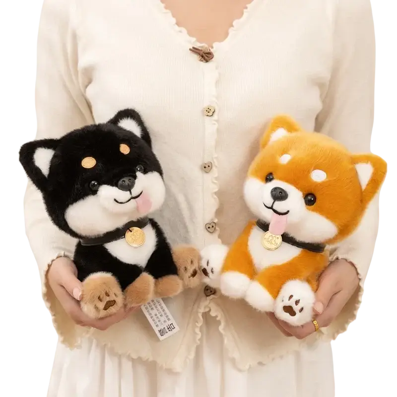 Two plush shiba inu stuffed animal toys in black white tan and orange white colors with black collars and gold tags