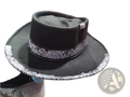 Plush skull cowboy hat in black felt with a wide brim and white patterned band around the crown