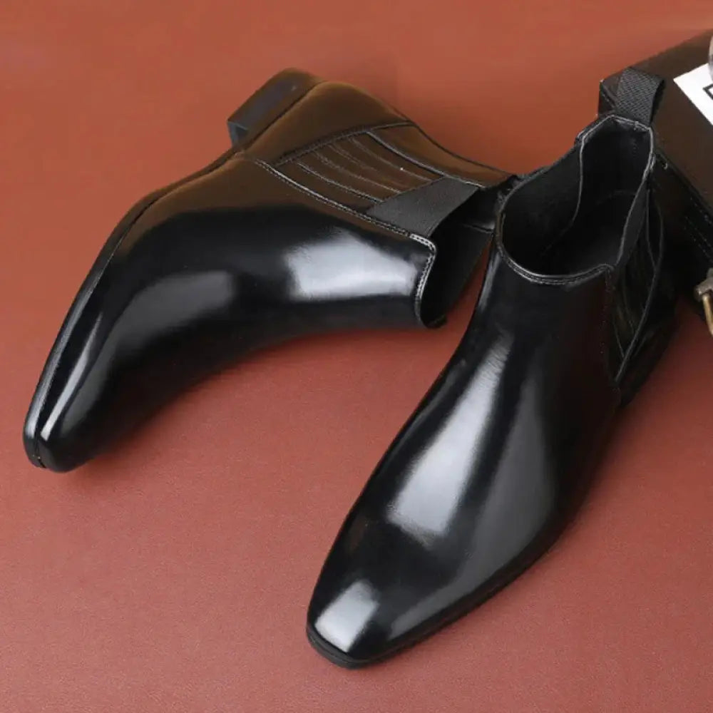 Men’s formal black patent leather Chelsea boots with pointed toe and subtle stitching details