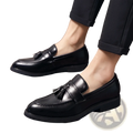 Black leather tassel loafers for men with polished finish and low heel for formal and casual wear