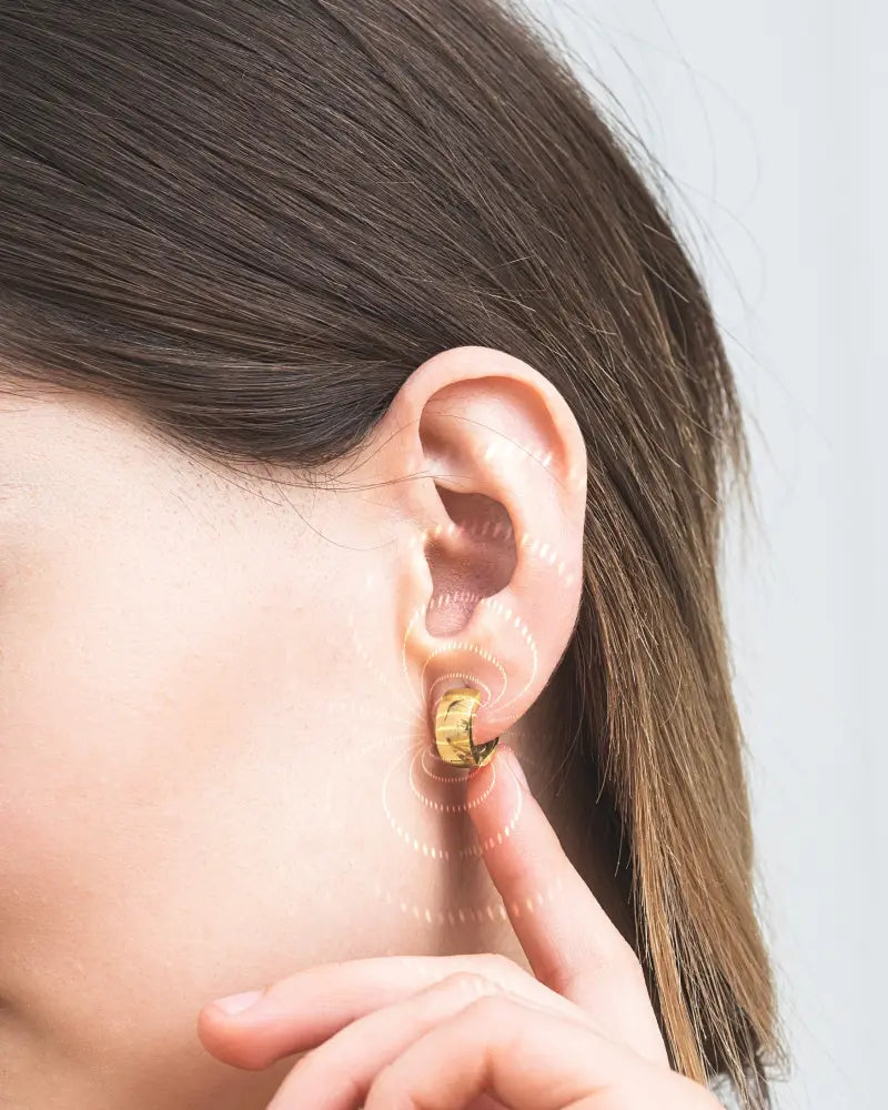 Polished gold magnetic rectangular hoop earring in gold tone with a textured slightly curved huggie design