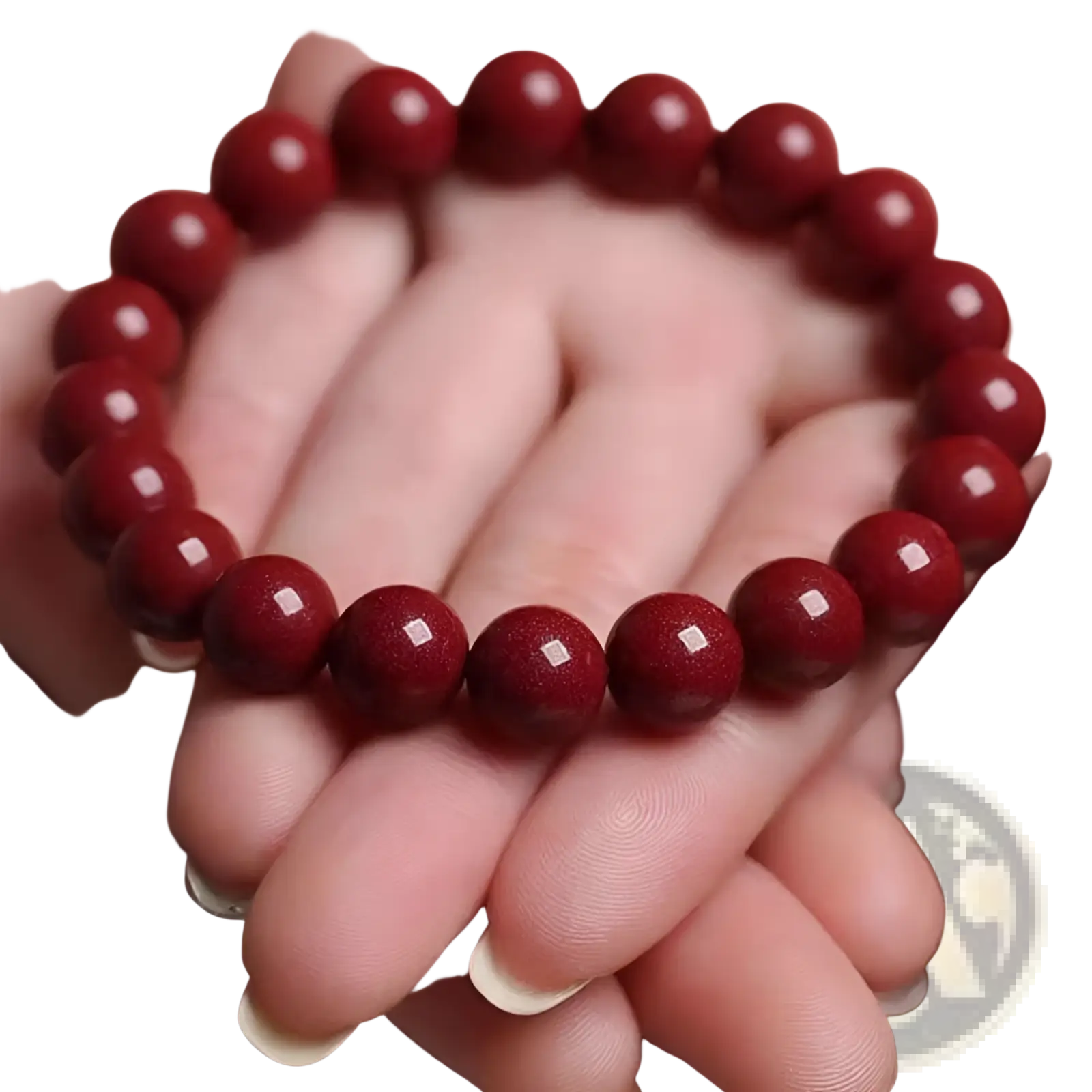 A polished red cinnabar spherical bead bracelet held in hand showcasing smooth deep red beads