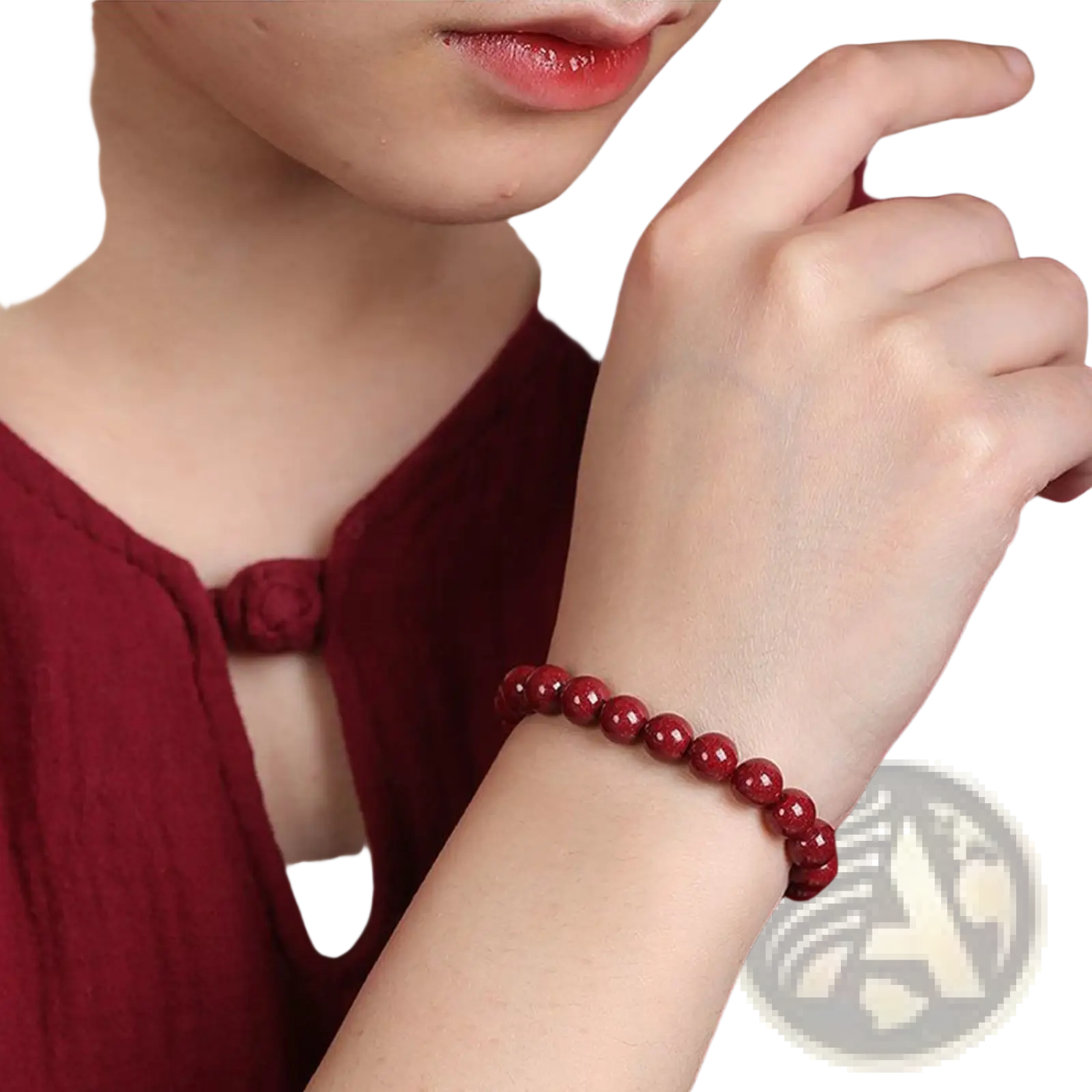 A vibrant red polished cinnabar spherical bead bracelet with a smooth surface worn on a wrist