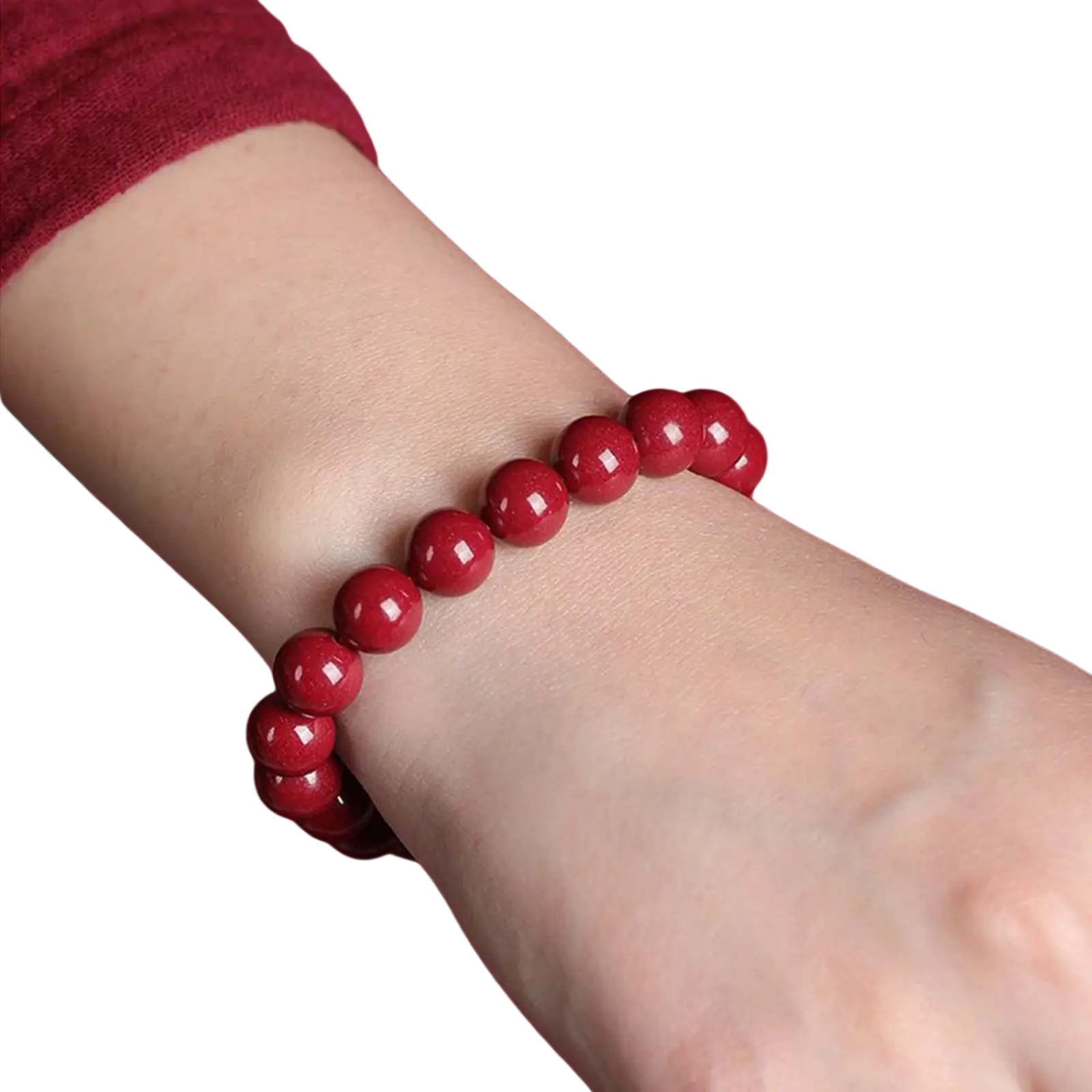 A polished red cinnabar spherical bead bracelet with vibrant glossy beads worn on a wrist