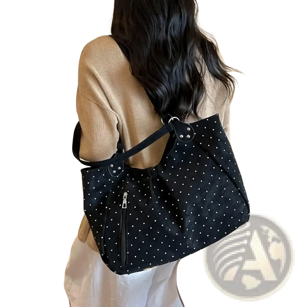 Black polka dot canvas tote bag with large capacity, silver toned hardware, and front zipper for convenient use