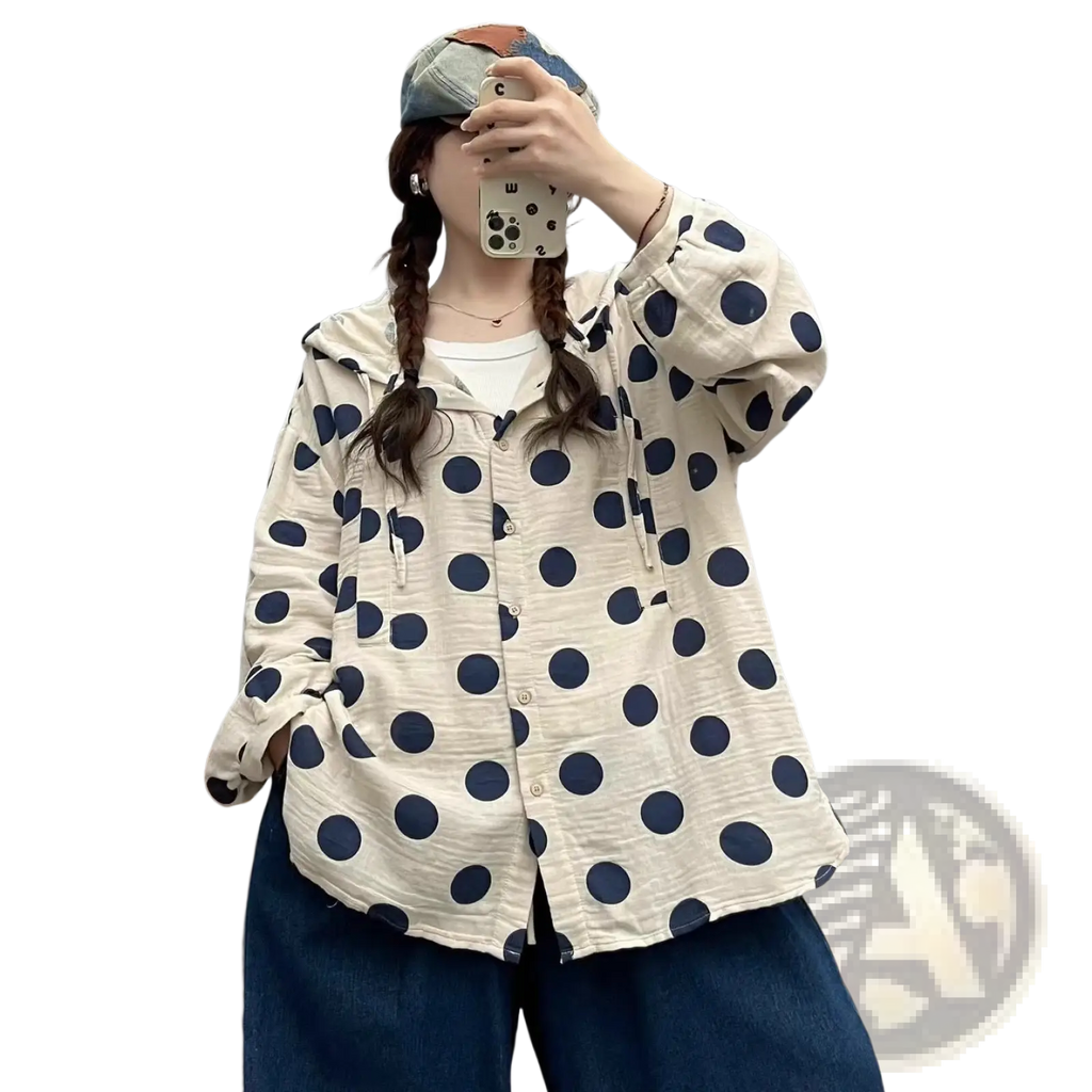 A cream-colored polka dot cardigan hoodie with navy blue dots and subtle textured fabric in long sleeves