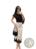Black patent leather handbag with glossy finish and distinctive ysl logo paired with polka dot lace midi skirt