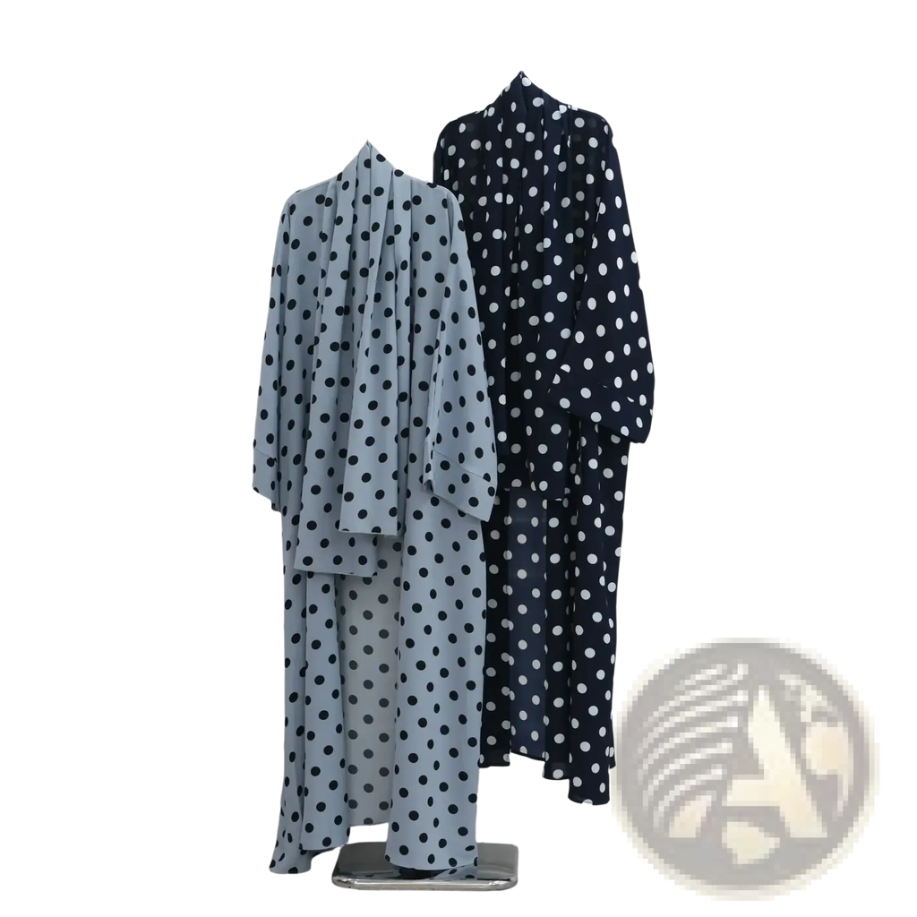 Two polka dot Muslim abaya set robes in light blue navy and black white hanging on a metal rack in Dubai Hijab dress style