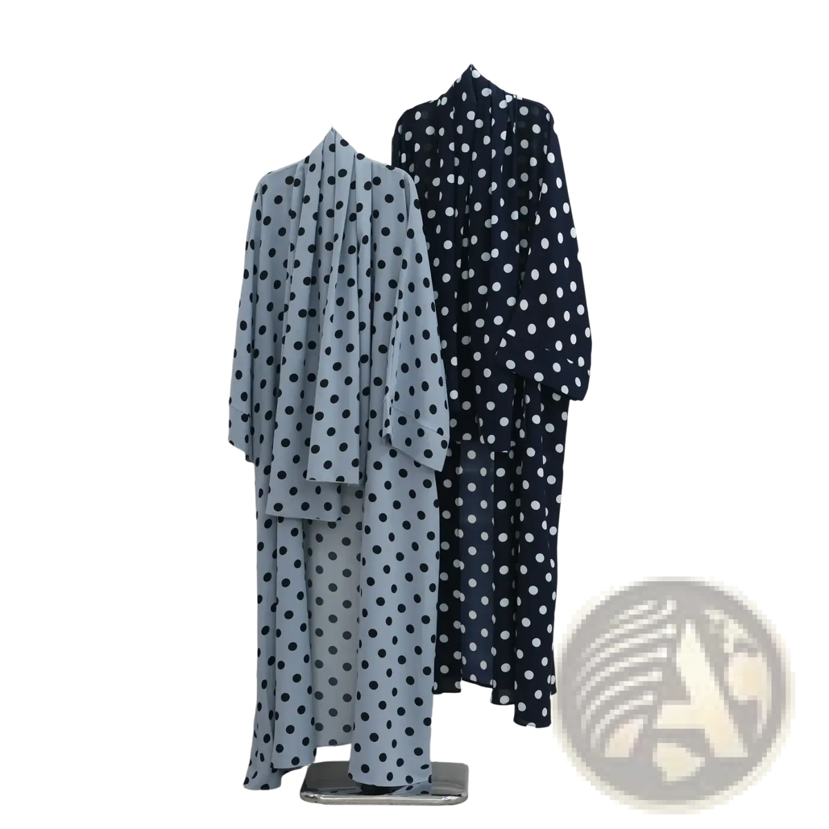 Two polka dot Muslim abaya set robes in light blue navy and black white hanging on a metal rack in Dubai Hijab dress style