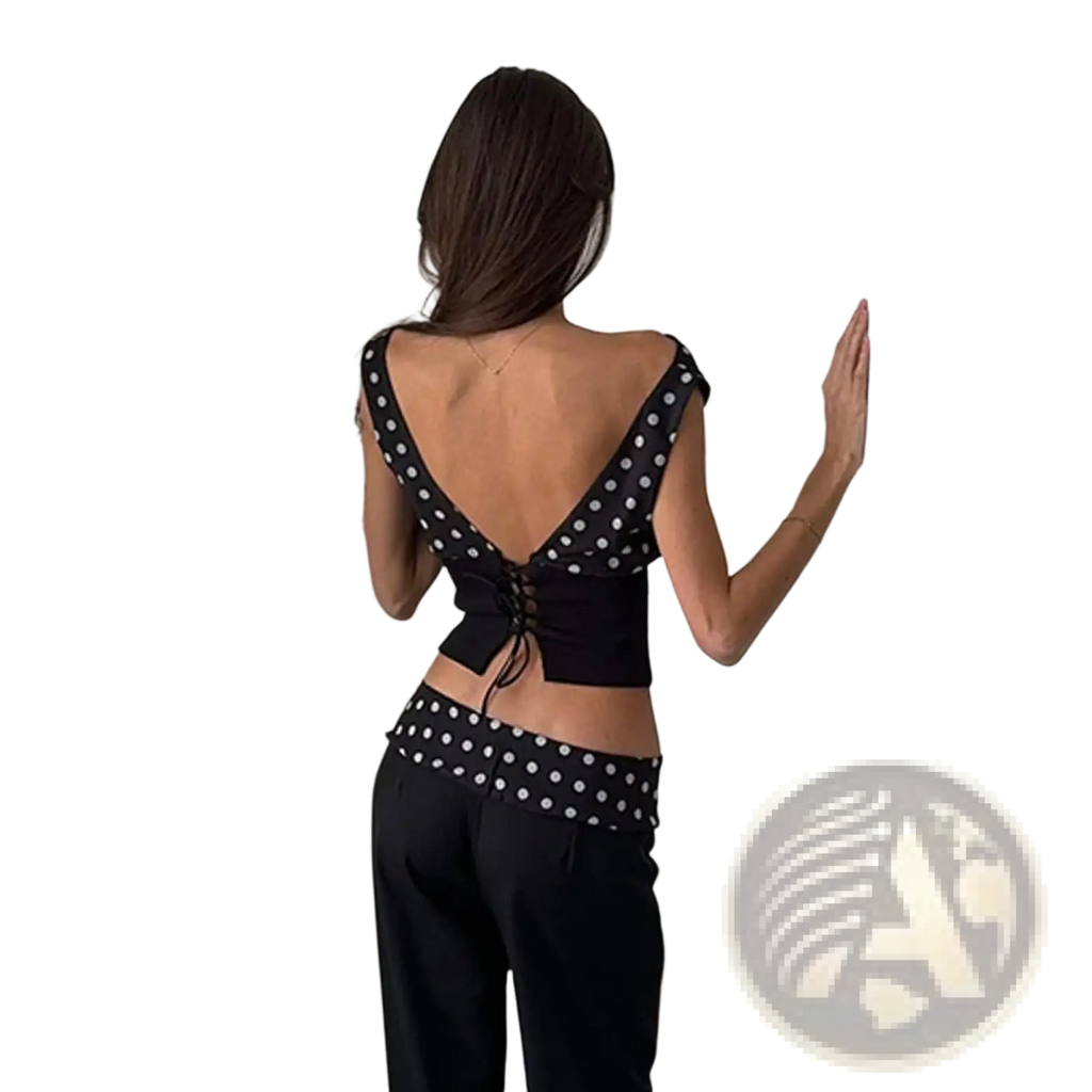 Back view of a black chiffon polka dot one shoulder crop top with a lace up back design
