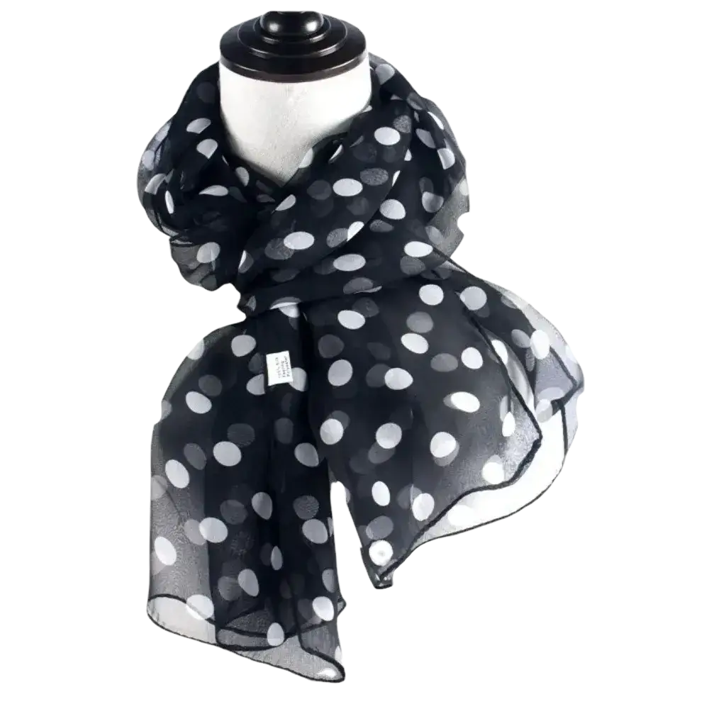 Black sheer silk head wrap scarf with white polka dots draped around a mannequin neck as a stylish wrap scarf