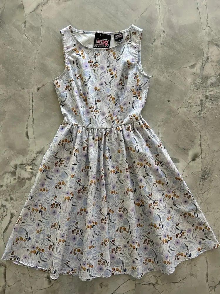 A sleeveless white Pollinators vintage blue floral cotton A-line dress with purple brown and gray floral pattern and pockets