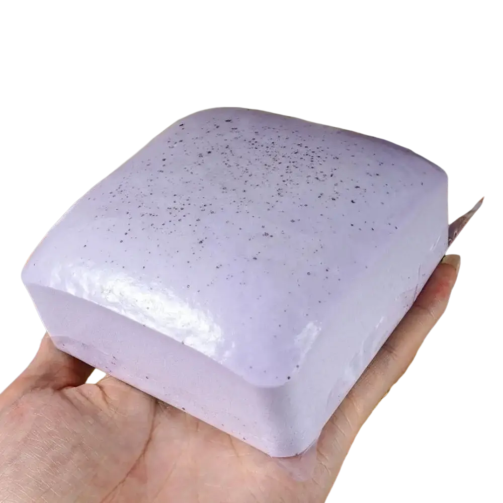 A lavender-colored speckled soap bar with a glossy finish displayed alongside a polyester acrylic winter scarf product