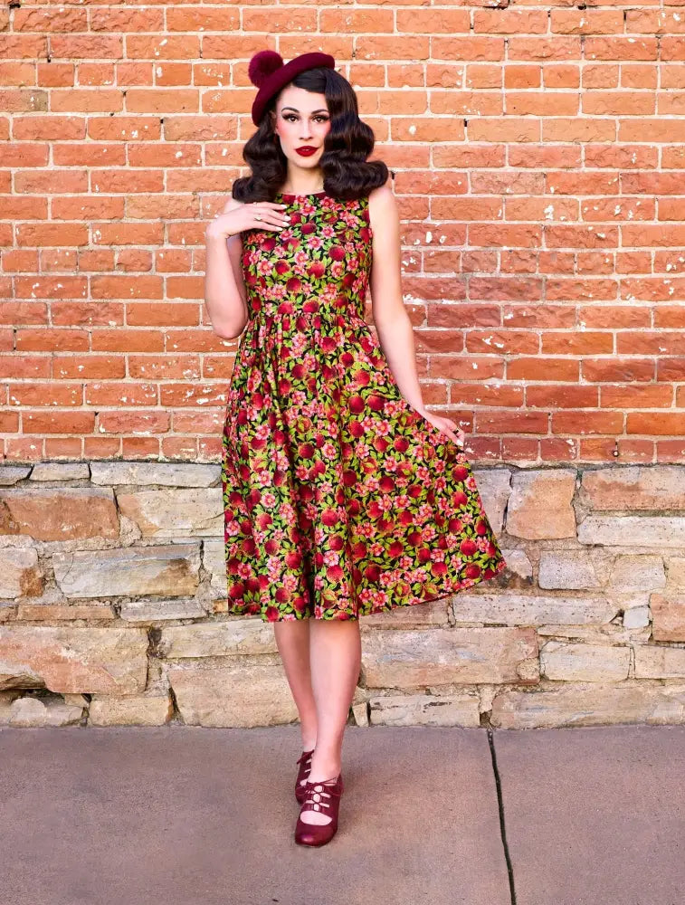 A vintage-style pomegranate floral 1950s cotton swing midi dress with fitted bodice flared skirt and sleeveless design