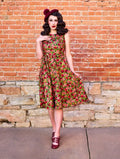 A vintage-style pomegranate floral 1950s cotton swing midi dress with fitted bodice flared skirt and sleeveless design