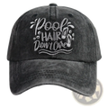 Dark gray distressed cotton baseball cap with embroidered white pool hair dont care text and decorative wave motifs