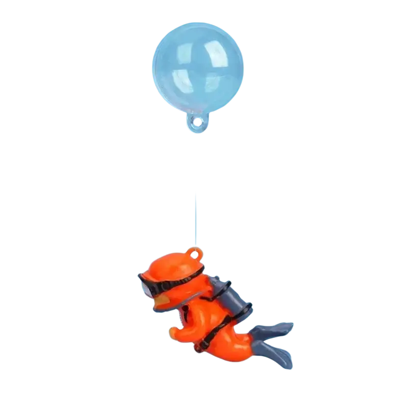 Orange plastic scuba diver figurine with black goggles and gray fins suspended by clear balloon for aquarium decor