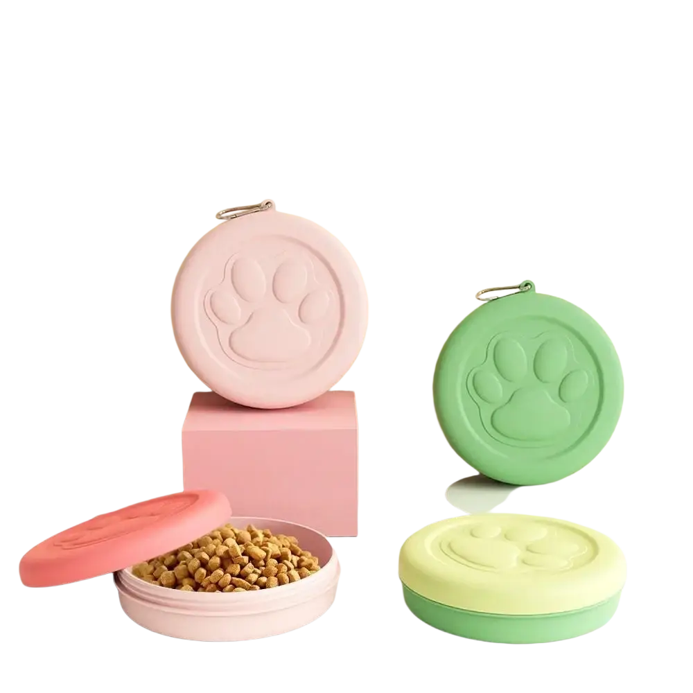 Portable dog travel bowls with treat storage in pastel pink and green featuring embossed paw prints and circular design