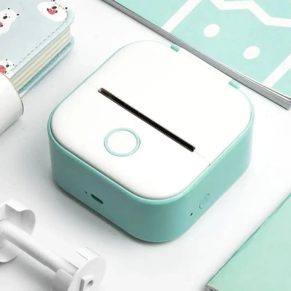Portable bluetooth mini thermal label and photo printer with a compact white top and mint green sides
