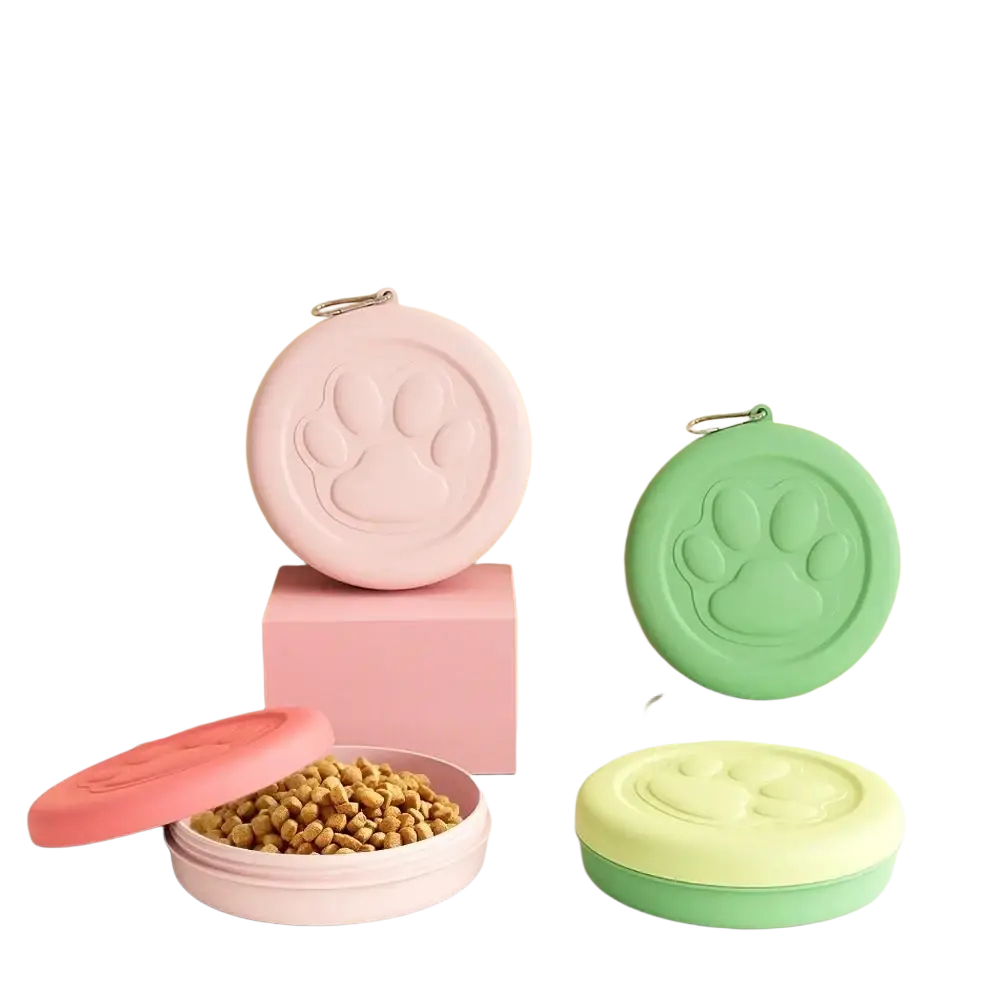 Portable travel dog bowl in pastel pink and green with embossed paw prints and integrated treat compartment