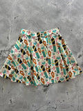 Potion skater skirt with a playful pattern of colorful potion bottles skulls and magical orbs on an off-white background