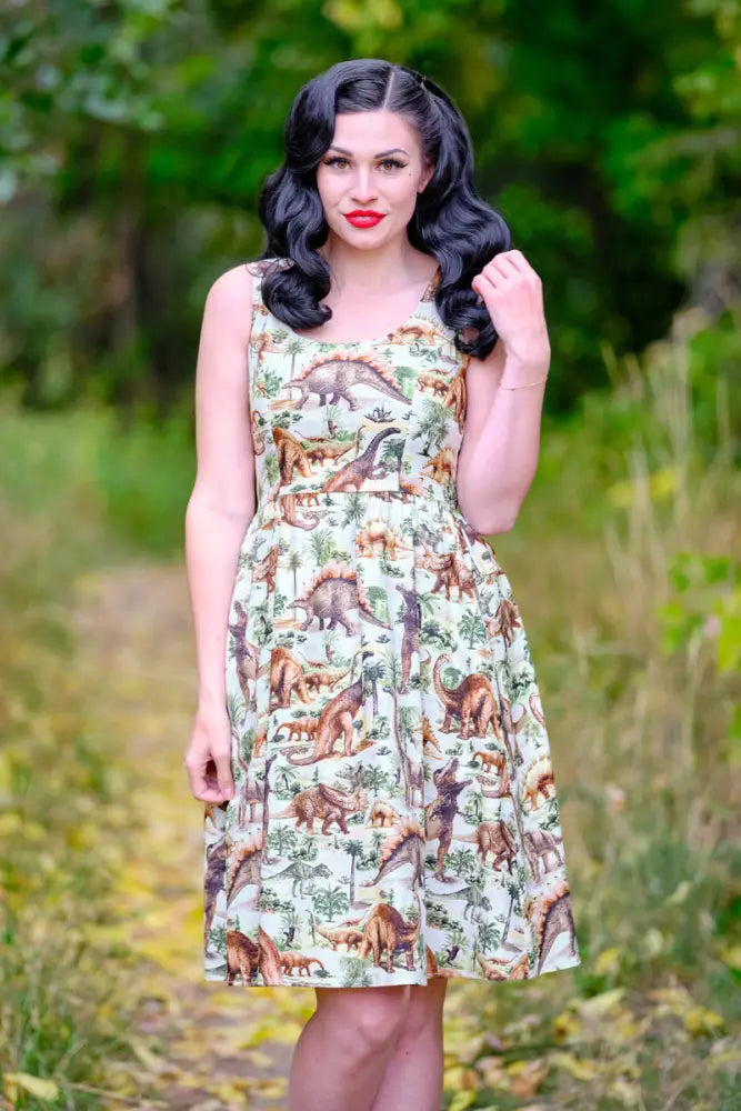 Sleeveless knee-length cotton a-line dress in light cream with vintage prehistoric dinosaur and plant print