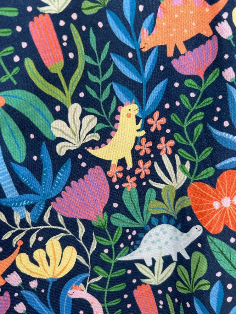 Prehistoric dinosaur floral print skater skirt in vibrant navy blue patterned fabric with dinosaur and floral motifs