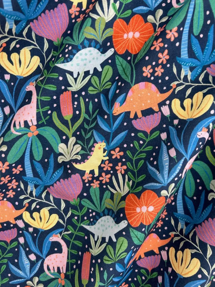 Vintage 1950s cotton a-line dress in navy blue with vibrant dinosaur and floral patterned fabric
