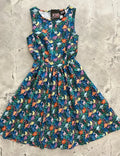 A vintage 1950s sleeveless cotton a-line dress in deep teal with colorful dinosaur and floral print