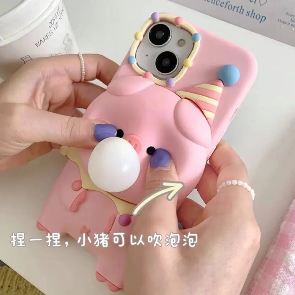 Pink silicone pig-shaped phone case with party hat and bubble popping stress relief feature back side view