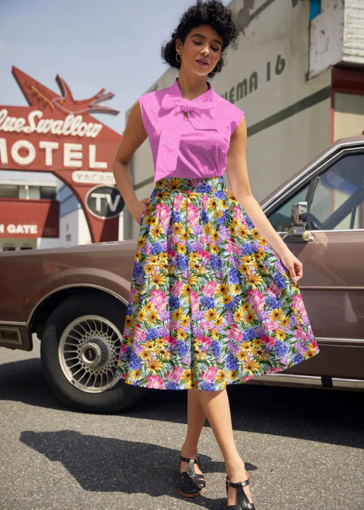 A vibrant floral print cotton midi skirt with a full flared silhouette with colorful blossoms