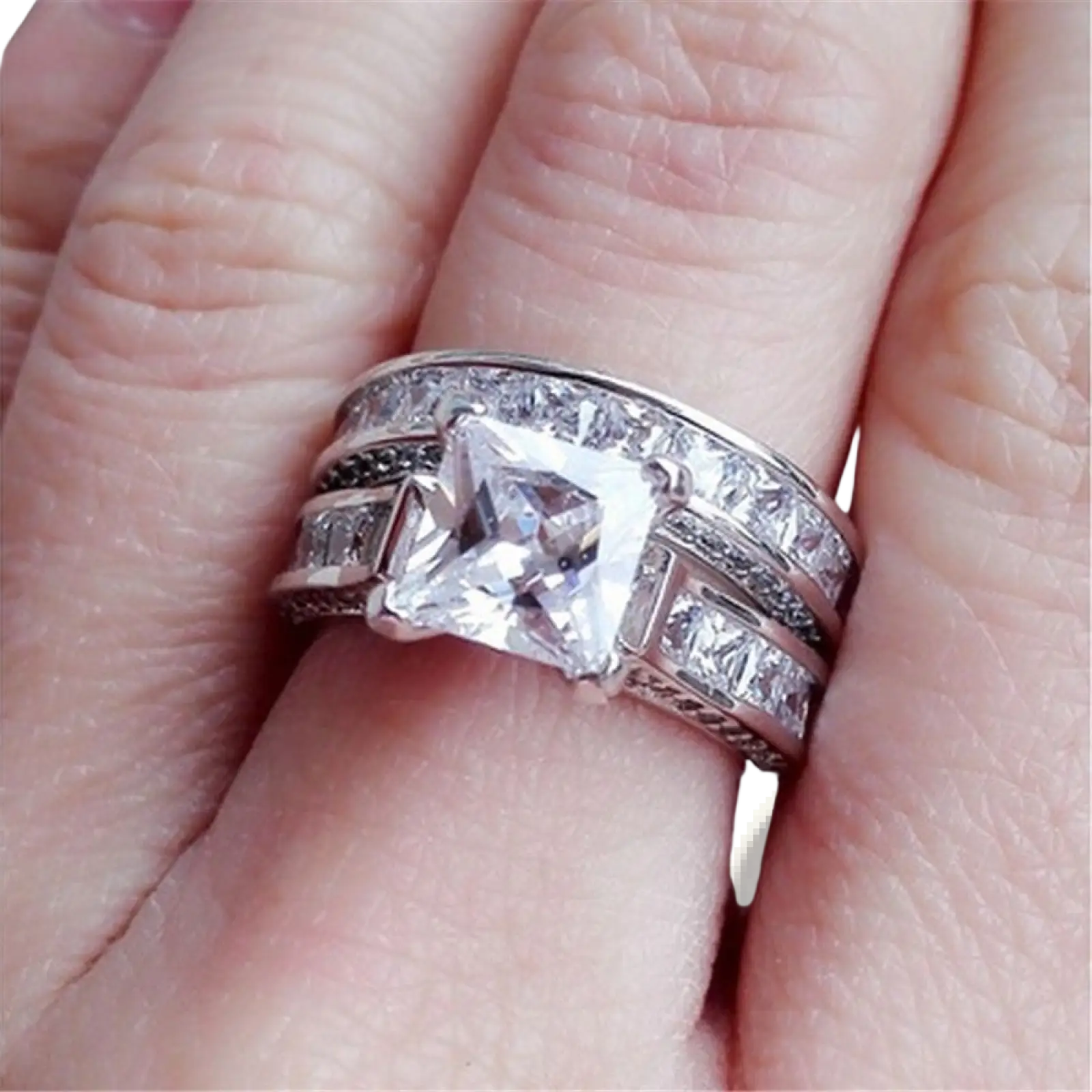Silver couple anniversary ring set featuring a princess cut cz center stone with baguette and round accents