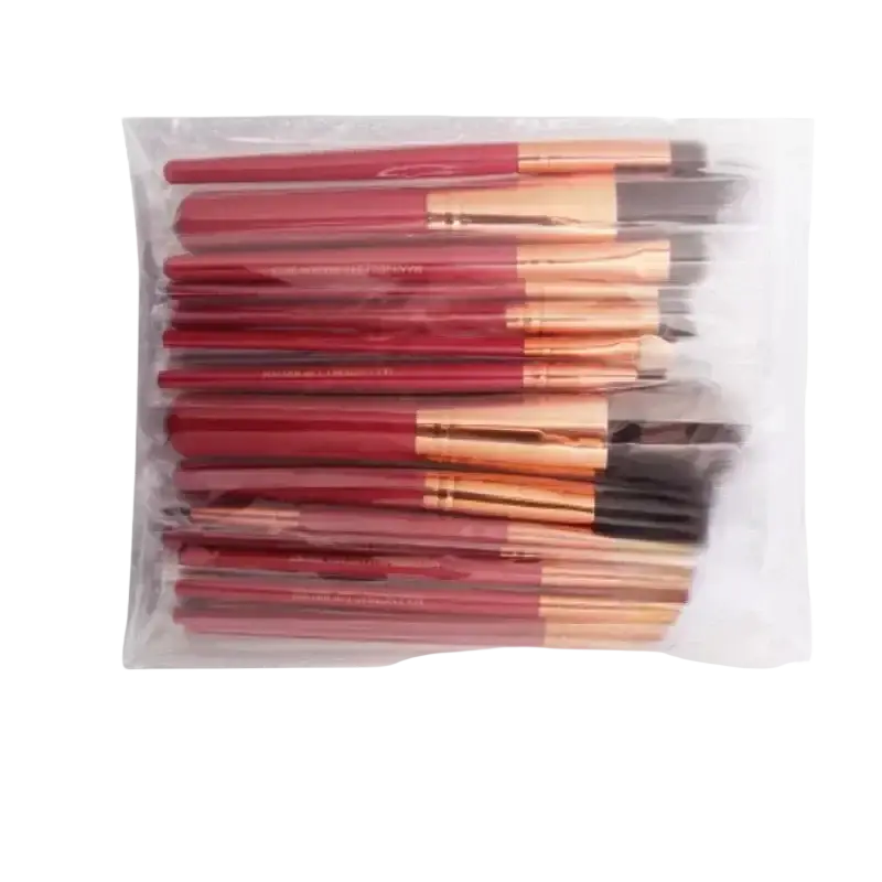 Professional synthetic hair makeup brush set with red and rose gold brushes in clear packaging display