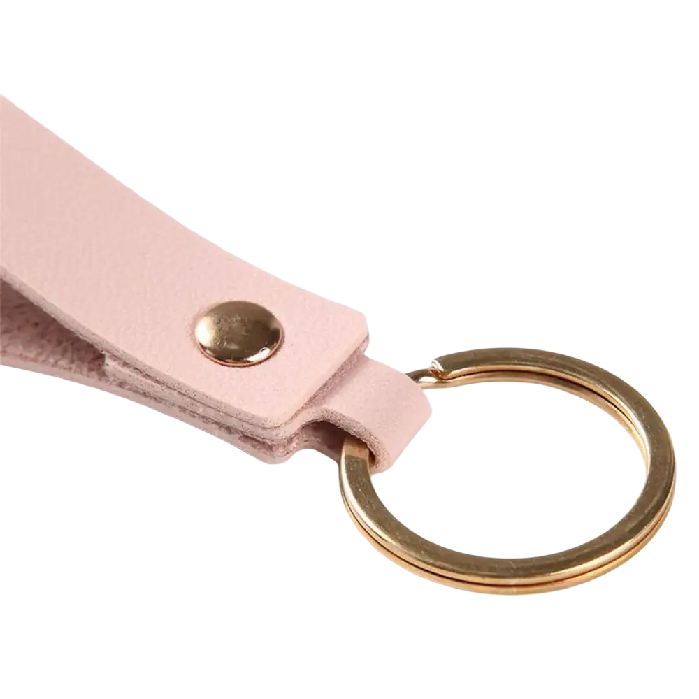 A delicate pink pu leather keychain with gold-toned metal ring and button for fashion metal keyring use